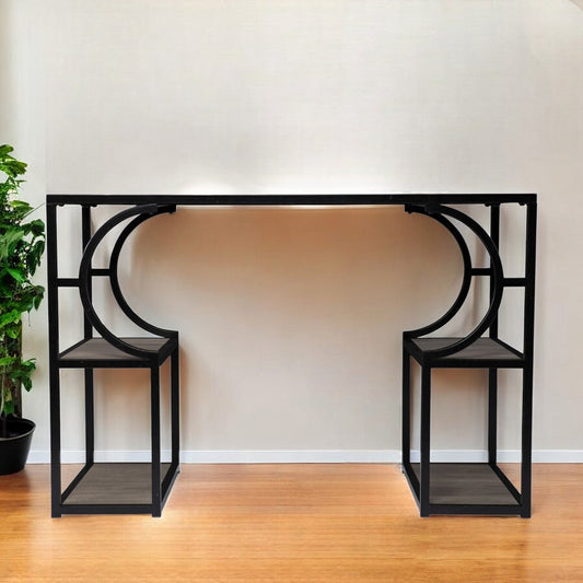 Black metal console table with curved design against a white wall.